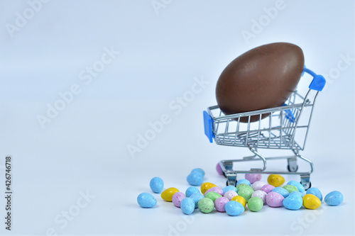Canvas Print Shopping trolley with chokolate multicolored easter eggs on white background