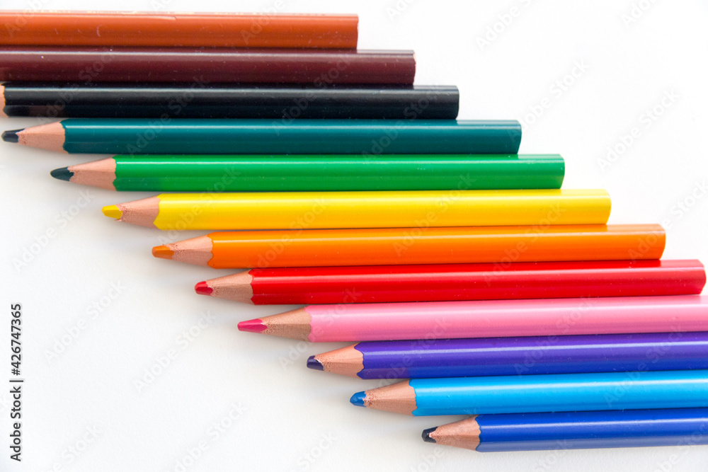 Top view of a series of colorful thick wooden crayons with tips and rears, diagonally arranged in the frame. Top view of a series of colorful thick wooden crayons with tips and rears, diagonally arranged in the frame.