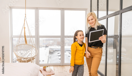 happy mother and daughter holding digital tablet