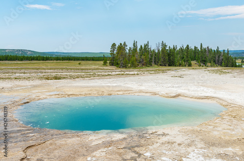 Blue hot spring hole by the Grand Prismatic Spring, Midway Norris geyser basin, Yellowstone national park, Wyoming, USA.