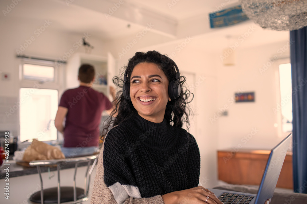 Happy woman with headphones working from home at laptop Happy woman with headphones working from home at laptop
