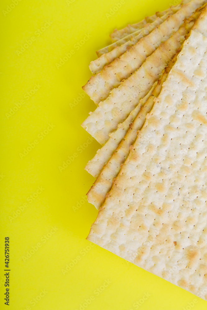 Fototapeta premium Pesach matzo on a yellow background.Vertical frame