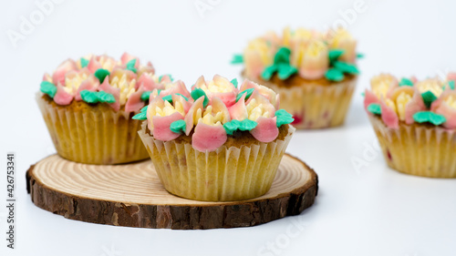 Four cupcakes on a wooden plate