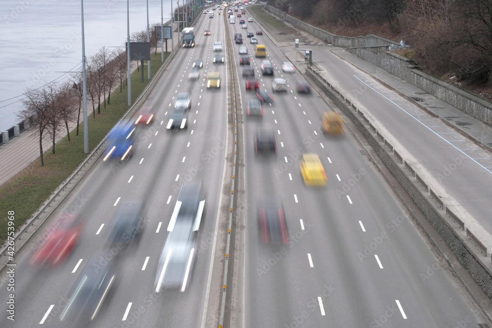 Cars blurred in motion at speed. Evening traffic, cars on the highway in the city Cars blurred in motion at speed. Evening traffic, cars on the highway in the city