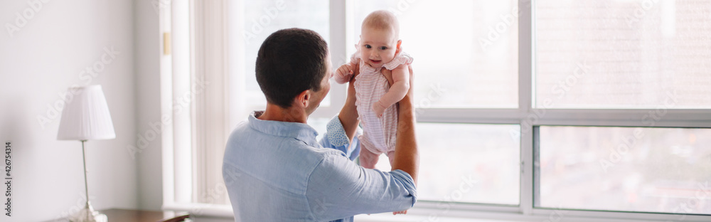 Fathers Day holiday. Middle age Caucasian father holding newborn baby. Man parent playing with child. Authentic lifestyle touching tender moment. Single dad family life. Web banner header. Fathers Day holiday. Middle age Caucasian father holding newborn baby. Man parent playing with child. Authentic lifestyle touching tender moment. Single dad family life. Web banner header.