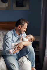 Fathers Day holiday. Middle age Caucasian father with sleeping newborn baby girl. Parent holding rocking child daughter son in hands arms. Authentic lifestyle parenting fatherhood moment.
