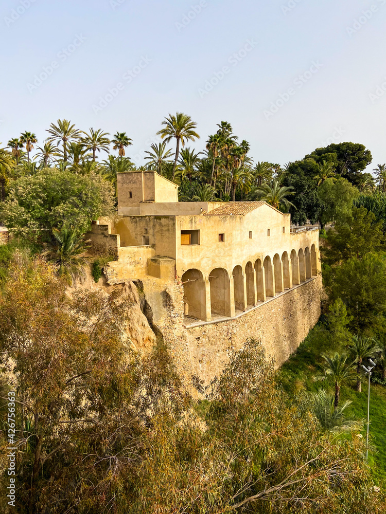 Old arabic fortification surrounded by palm trees in Alicante, Spain.