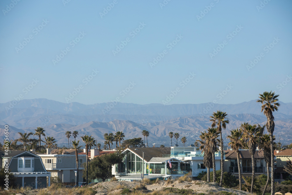 Sunset view of coastal dunes and houses in Oxnard, California, USA.