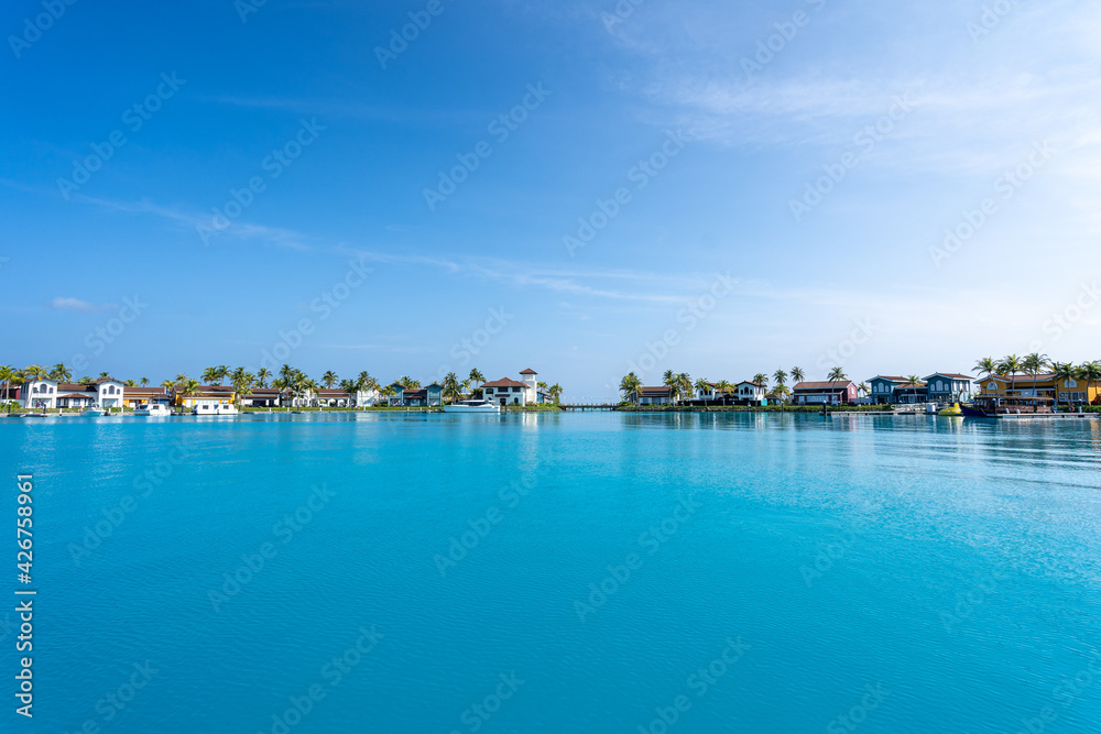 Blick auf den Hafen einer Insel auf den Malediven mit kleinen Häusern und Booten im Hintergrund