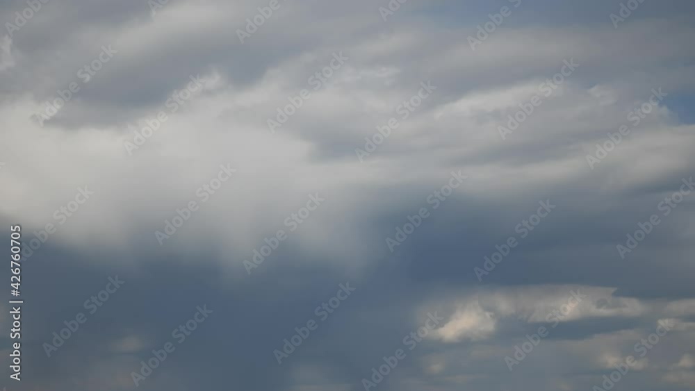 Time lapse of overcast sky with grey cumulus clouds with rain flow moving fast by wind. Dramatic sky cloudscape with rain and dark clouds