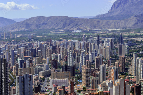 View of the skyscrapers of Benidorm during the day in sunny weather. Benidorm, Spain summer resort and famous skyscrapers against the backdrop of cinematic mountains