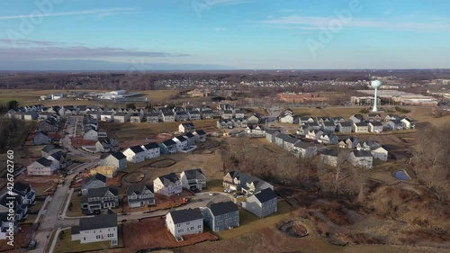 Circling above a modern upper middle class single family homes neighborhood street American real estate in a new construction area in Maryland USA, blue sky 4K	
