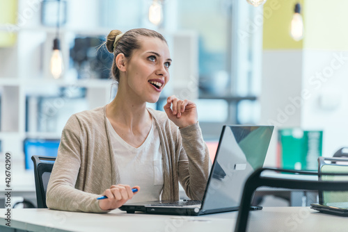 Blonde manager working behind her desk in a modern office.