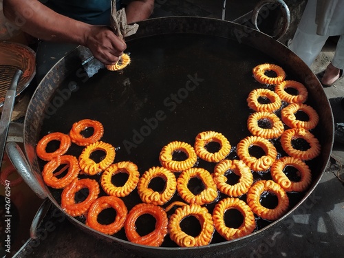 Imarti or Amriti is a sweet from India. It is made by deep-frying vigna mungo flour batter in a circular flower shape, then soaking in sugar syrup. photo