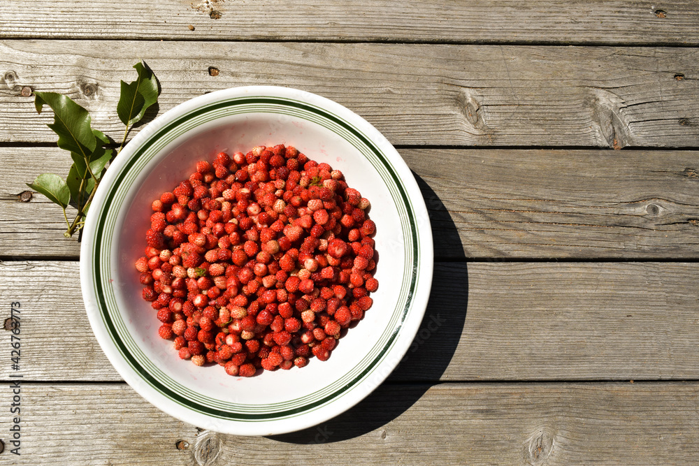 Fresh strawberries in a plate isolated on a wooden background. Top view of strawberries on the table. Summer fruits background, banner, copy space for text. View from above. Flat lay Fresh strawberries in a plate isolated on a wooden background. Top view of strawberries on the table. Summer fruits background, banner, copy space for text. View from above. Flat lay