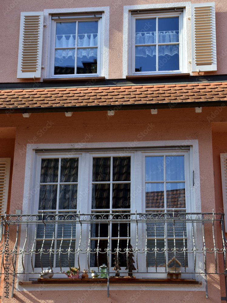 Fenster an einer rosaroten Altbaufassade