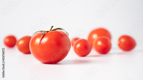 Juicy tomatoes scattered on a white background. Side view. White and red.