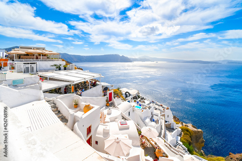 The whitewashed hillside town of Oia, Greece, filled with cafes and hotels overlooking the Aegean Sea and Caldera.