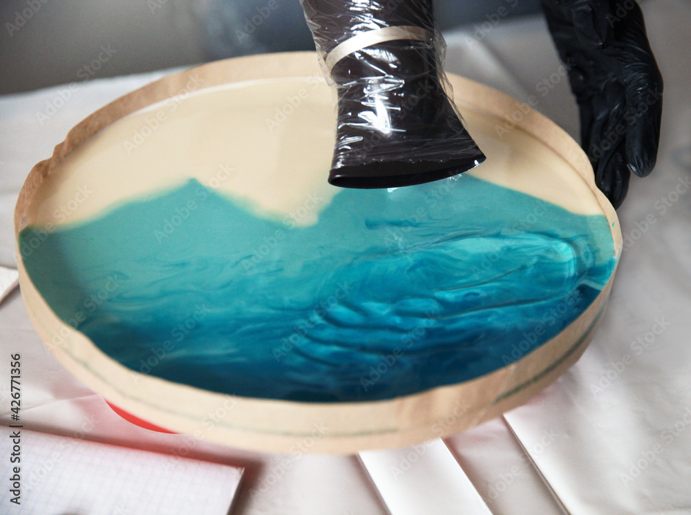 The epoxy resin is blown with a hair dryer. The process of creating a  picture of the sea Stock Photo | Adobe Stock