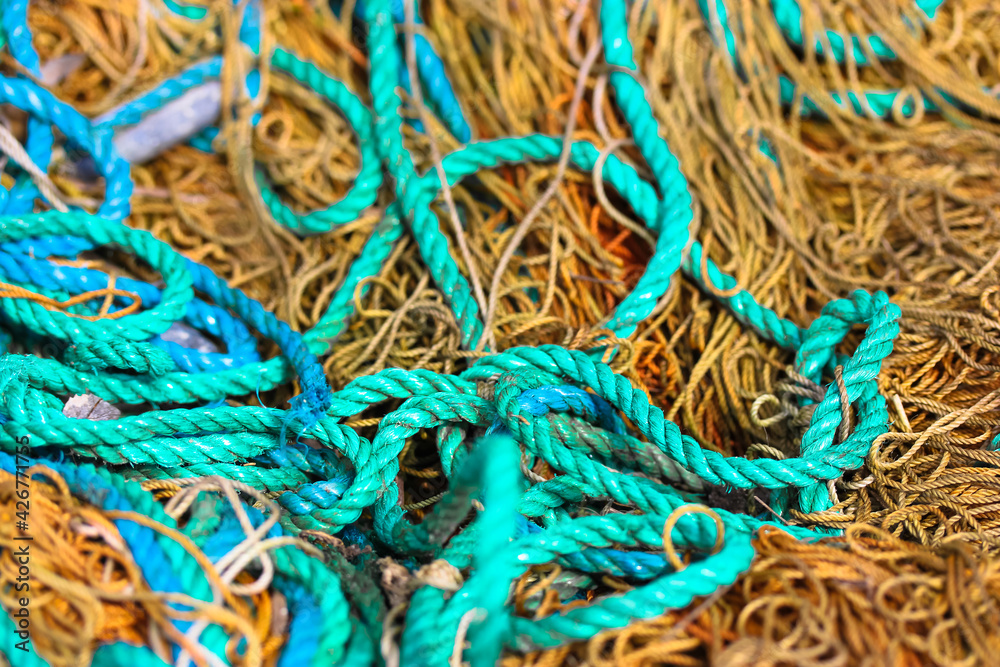Various rough ropes scattered in a chaotic order, view from above. Brown and blue ropes from above. Navy texture. Maritime ropes texture close-up. Safety rope texture.