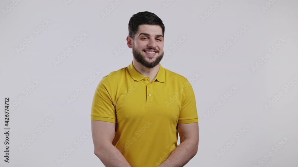 Portrait of cheerful georgian man looking to camera. Young handsome kind guy with beard smiling in studio on white background.