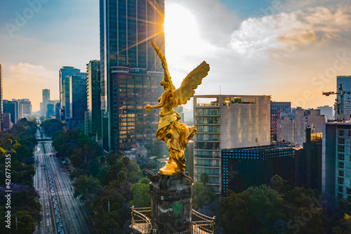 El Angel de la independencia tomado con drone luciendo su color oro con reforma como fondo en la bella ciudad de mexico photo