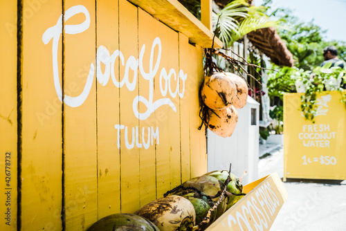 A wooden yellow fresh coconut stand in Tulum Mexico photo