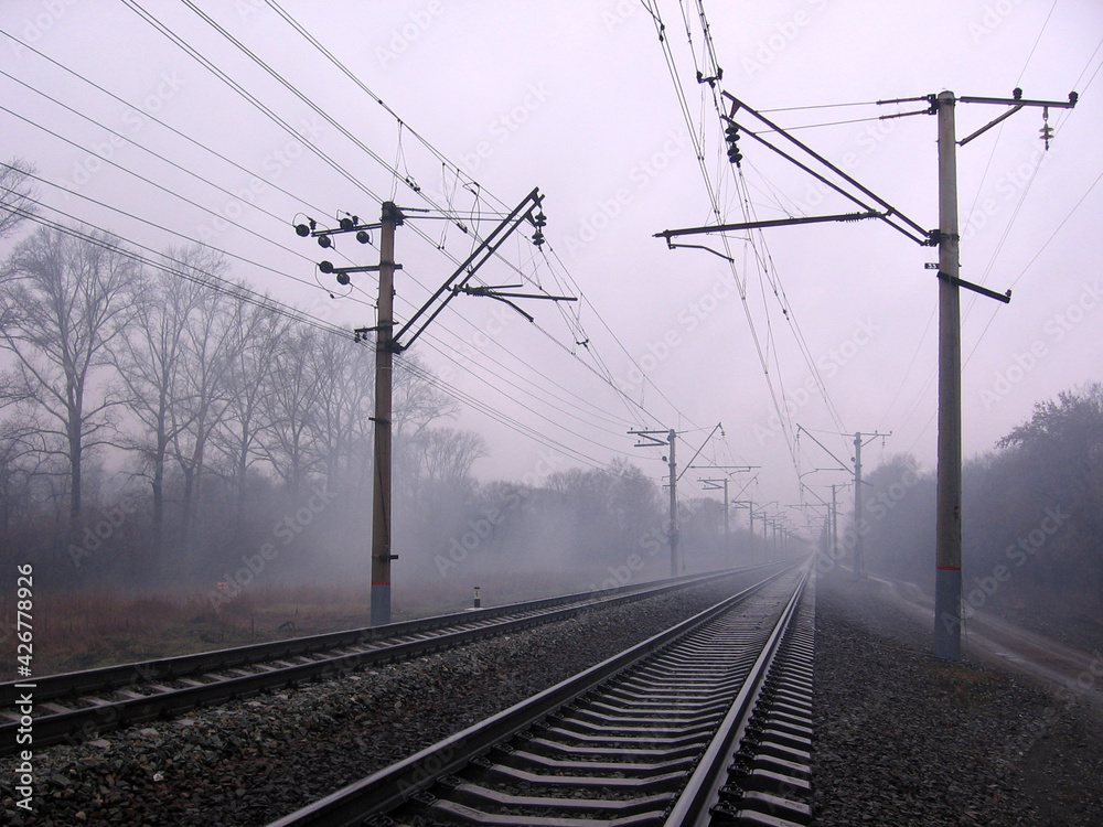 railway rails for a train in the fog journey into the distance