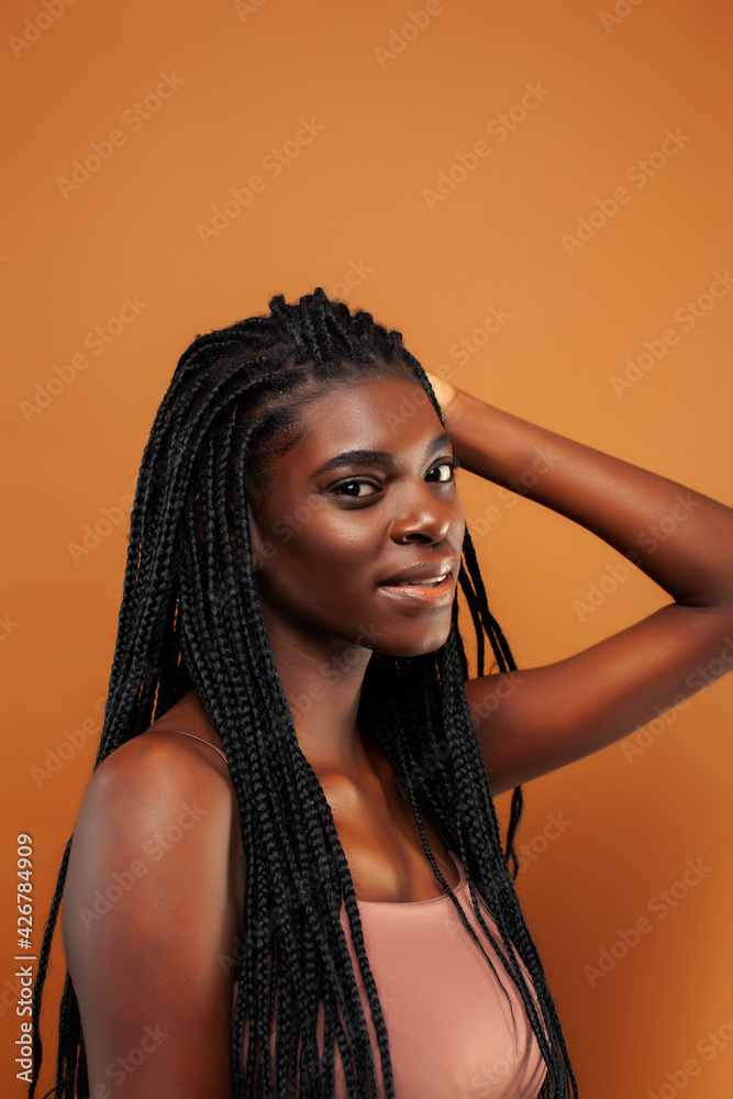 pretty young african american woman with braids posing cheerful gesturing on brown background, lifestyle people concept pretty young african american woman with braids posing cheerful gesturing on brown background, lifestyle people concept