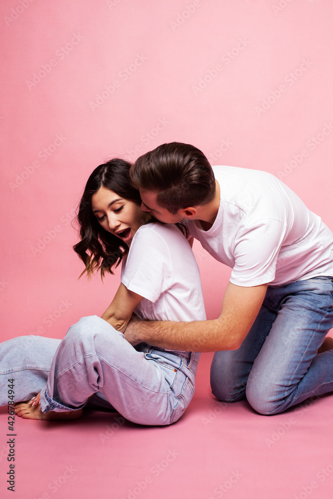 young cheerful caucasian couple together having fun on pink background, guy ang girl modern relationship, lifestyle people concept young cheerful caucasian couple together having fun on pink background, guy ang girl modern relationship, lifestyle people concept