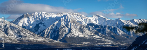 Snowy winter mountain range in Banff National Park in Alberta Canada on sunny day with blue sky. © Kellee Kovalsky