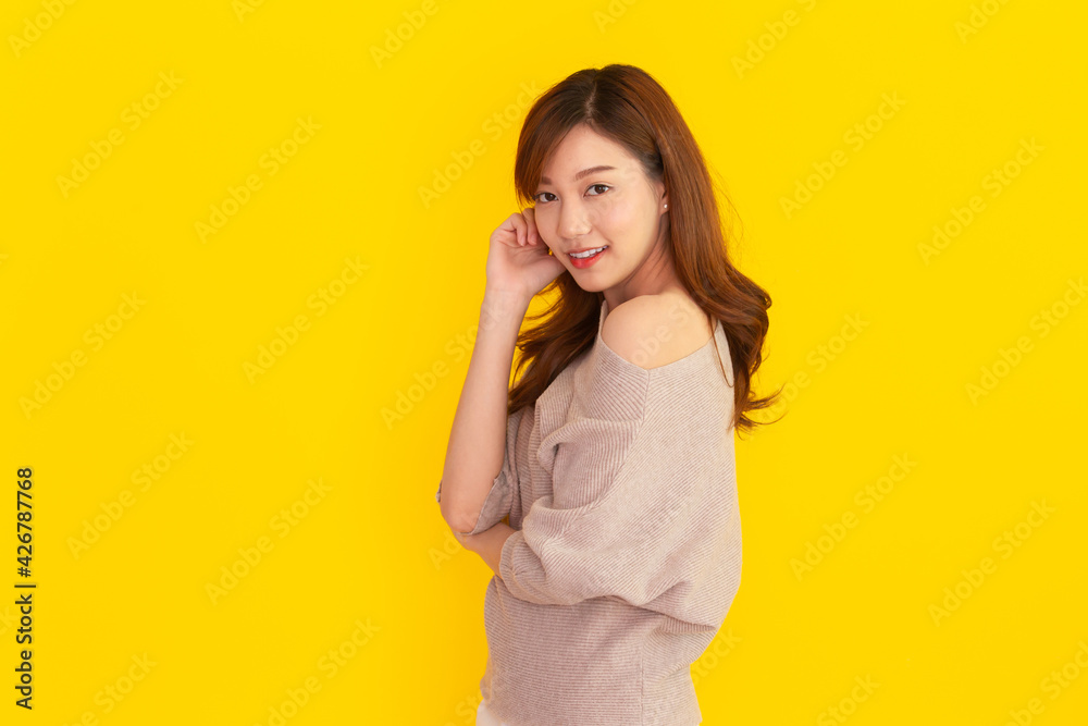 Beautiful Asian young woman's portrait on bright yellow background Beautiful Asian young woman's portrait on bright yellow background
