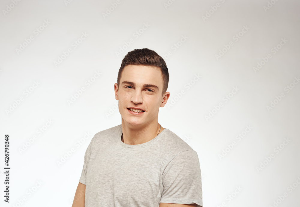 handsome man in a t-shirt gesturing with his hands emotions studio light background handsome man in a t-shirt gesturing with his hands emotions studio light background