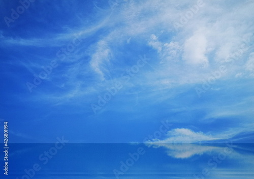 Blue sky and white clouds reflected on the water surface.