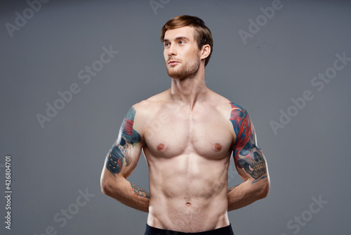 sport man cropped view workout tattoo on arms gray background