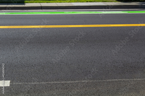 Road markings on gray asphalt, yellow and bright green lines