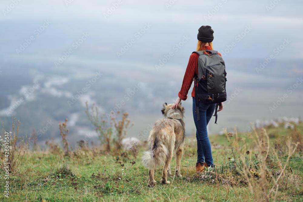 woman hiker with backpack with dog in the mountains travel friendship woman hiker with backpack with dog in the mountains travel friendship