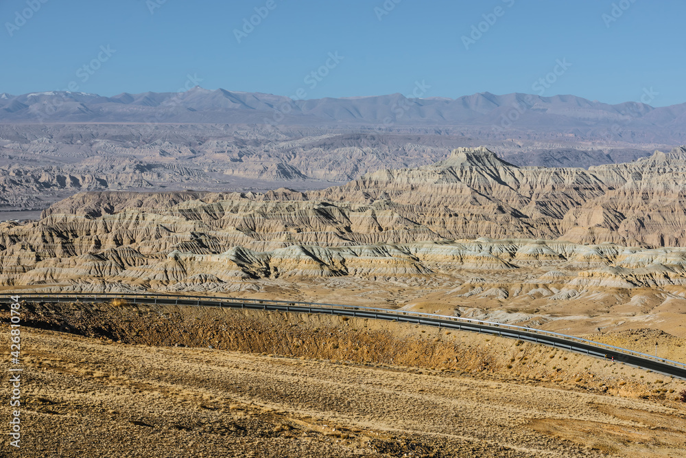 Naklejka premium A section of tarmac road in the eroded landscape and rock towers of Zanda soil forest