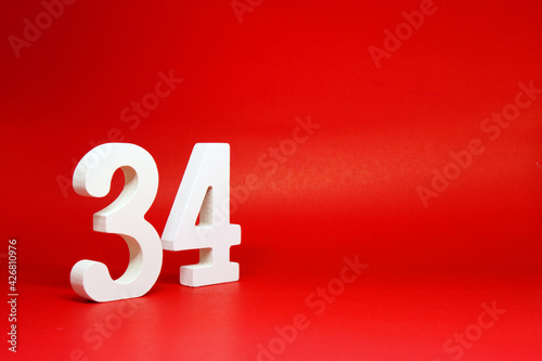 Thirty Four ( 34 ) white number wooden Isolated Red Background with Copy Space - New promotion 34% Percentage  Business finance Concept  photo