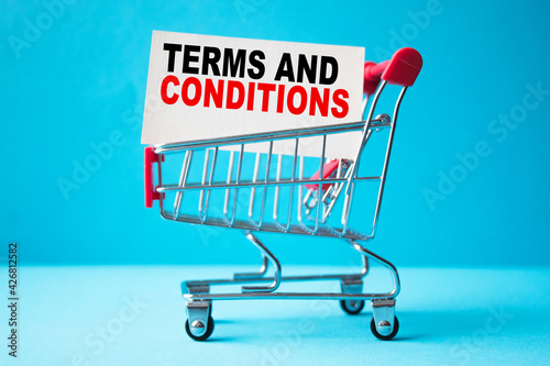 a business card with text TERMS AND CONDITIONS in a shopping cart. business and finance