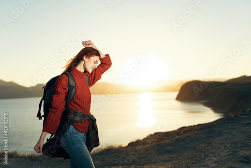 cheerful woman hiker with a backpack with hands raised up freedom landscape © SHOTPRIME STUDIO