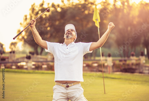 The senior golfer rejoiced at his victory. Man on golf filed.