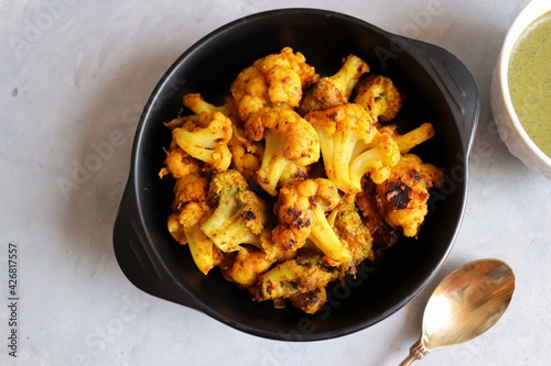 Gobi or Gobhi Tandoori. Masala Roasted cauliflower is a popular Indian vegetarian starter dish served with mint and coriander chutney. copy space. photo