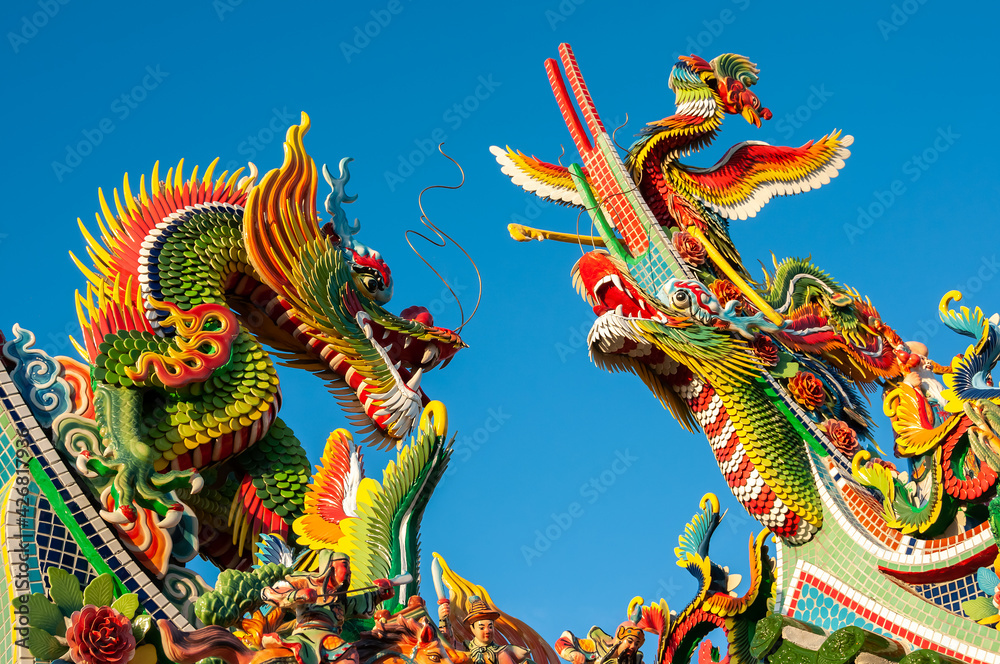 Amazing colorful Chinese figurines of two Dragons and Phoenix, one looking at the other in contrast to the super blue sky. Tourist spot on the island of Ishigaki. Amazing colorful Chinese figurines of two Dragons and Phoenix, one looking at the other in contrast to the super blue sky. Tourist spot on the island of Ishigaki.