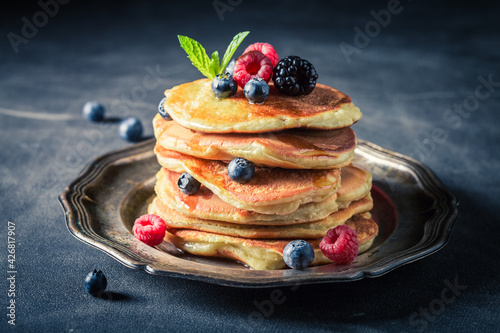 American pancakes with berries on dark table. Pancakes for breakfast.