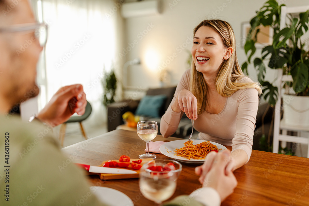 Photo of happy beautiful young woman having a romantic lunch and holding her boyfriend for hand. Photo of happy beautiful young woman having a romantic lunch and holding her boyfriend for hand.