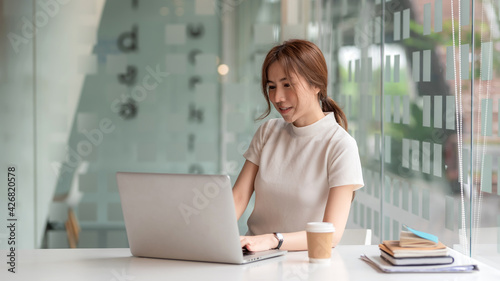 Image of Young Asian businesswoman working at the office using digital laptop.