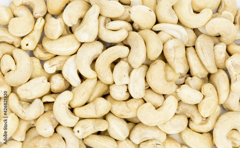 Raw cashew texture on white background. Natural organic nut kernel. Protein superfood or healthy snack. Cashew pile scattered on white table top view. White cashew package design. Healthy eating Raw cashew texture on white background. Natural organic nut kernel. Protein superfood or healthy snack. Cashew pile scattered on white table top view. White cashew package design. Healthy eating
