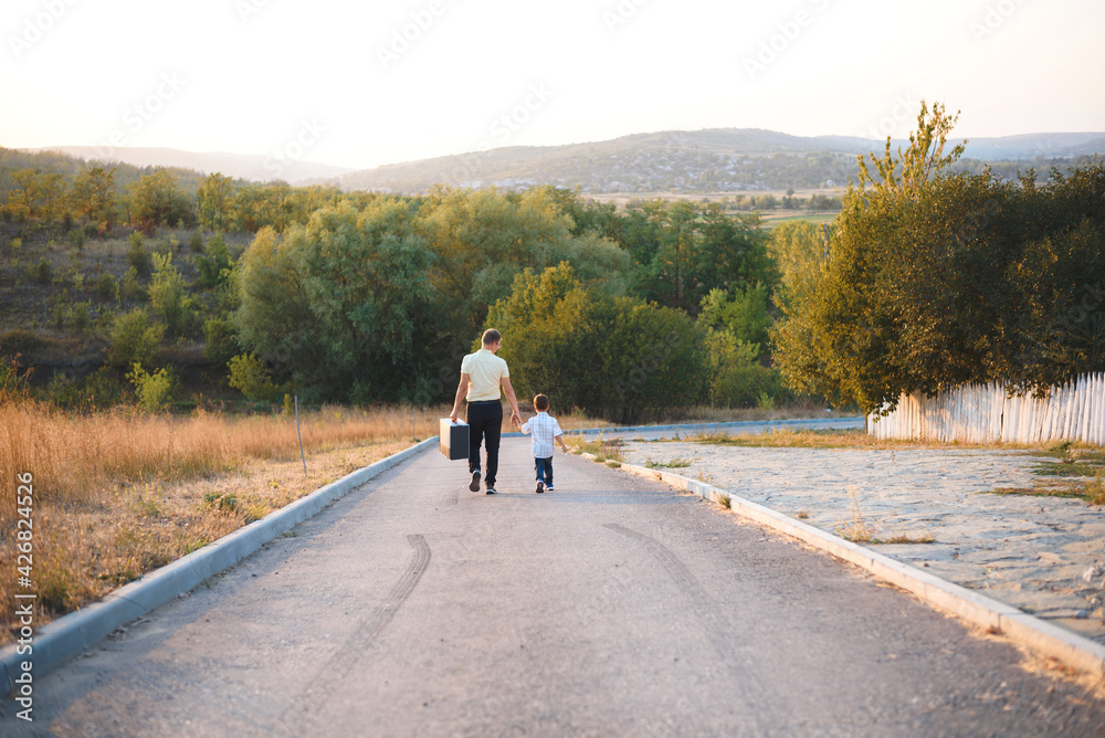 father with box walking with son