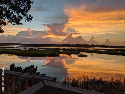 orange marsh sunset with high tide reflection